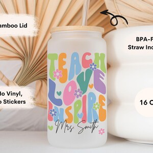 May include: A white 16 ounce reusable tumbler with a bamboo lid and a straw. The tumbler has a colorful graphic that says "Teach Love Inspire" with the name "Mrs. Smith" underneath.