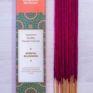 May include: A box of Spring Blossom incense sticks by Bhagwan Incense. The box is pink and green with a mandala design. The incense sticks are a deep pink color.