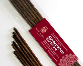 Peut inclure: Un paquet de bâtonnets d'encens au bois de santal et au safran. L'emballage est rouge et blanc avec un motif de mandala et le texte "GOOD INCENSE" et "SANDALWOOD SAFFRON".