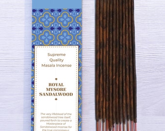 Peut inclure: Une boîte d'encens Royal Mysore Sandalwood bleu et or. La boîte présente un motif floral et le texte "Bhagwan Incense", "Supreme Quality Masala Incense", "Royal Mysore Sandalwood", et "The very lifeblood of the sandalwood tree itself, poured forth to create a Masterpiece of Sandalwood Incense for the true connoisseur."
