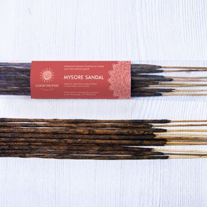 May include: A package of Good Incense Mysore Sandal incense sticks. The package is red and white with a mandala design. The sticks are brown and have a natural wood scent.