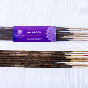 May include: A package of Good Incense Agarwood incense sticks. The package is purple with a mandala design and the text "Premium Masala Incense to make you feel good" and "Agarwood" in white. The sticks are brown and have a natural wood scent.