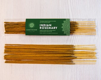Puede incluir: Dos paquetes de varillas de incienso Indian Rosemary en un envase de plástico transparente, con una etiqueta verde que dice "GOOD INCENSE" y "INDIAN ROSEMARY". Las varillas de incienso son marrones con puntas amarillas, sobre una superficie de madera blanca.