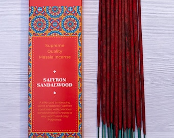Peut inclure: Une boîte d'encens au safran et au bois de santal de Bhagwan Incense. La boîte est rouge avec un motif de mandala doré et orange. Les bâtonnets sont rouges avec une base verte.