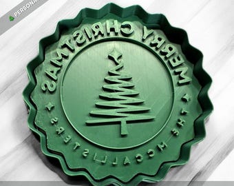 May include: A round green cookie cutter and stamp featuring a scalloped edge, a central Christmas tree graphic, and the embossed text MERRY CHRISTMAS THE MCCALLISTERS. The tool is designed for creating personalized holiday cookies.