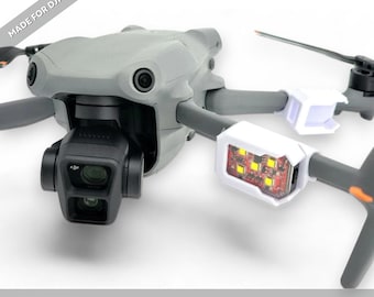 May include: A gray DJI Air 3 drone equipped with white Firehouse Technology Arc V arm mounts. The mounts feature red LED strobe lights and are attached to the front arms. The text MADE FOR DJI AIR 3 / 3S and MADE IN USA are visible.