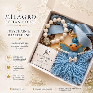 May include: A keychain and bracelet set in a white gift box. The bracelet features white faux pearls and a small iridescent flower charm. The keychain is an angel figure with a blue yarn skirt, blue wings, and a white bow. A card reads Milagro Design House.