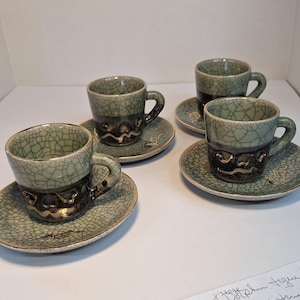 May include: Set of three vintage dark blue teacups with gold trim and a crackled glaze. Each cup is 8 inches long and in excellent condition.