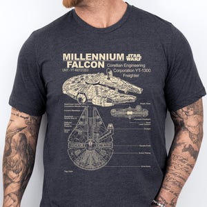 May include: Dark gray t-shirt featuring a detailed schematic of the Millennium Falcon, a Corellian Engineering Corporation YT-1300 Freighter, with the text "Millennium Falcon" and "Star Wars".