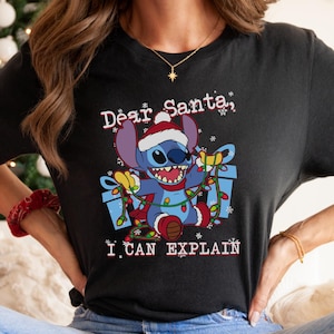 A woman wearing a black t-shirt with a graphic of a cartoon character and text that says "Dear Santa, I can explain".