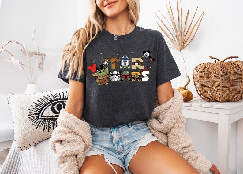 a woman sitting on a bed wearing a star wars shirt