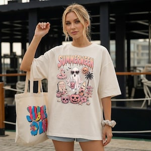 Könnte beinhalten: Ein cremefarbenes Kurzarm-T-Shirt mit einem Grafikdruck, der den Text SUMMERWEEN, einen Geist mit Sonnenbrille, einen rosa Flamingo-Schwimmring, einen Kürbis, einen Grabstein, ein Surfbrett und Palmen zeigt. Eine passende Stofftasche ist dabei.