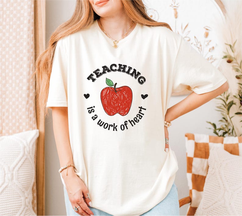 a woman wearing a teaching is a work of heart t - shirt