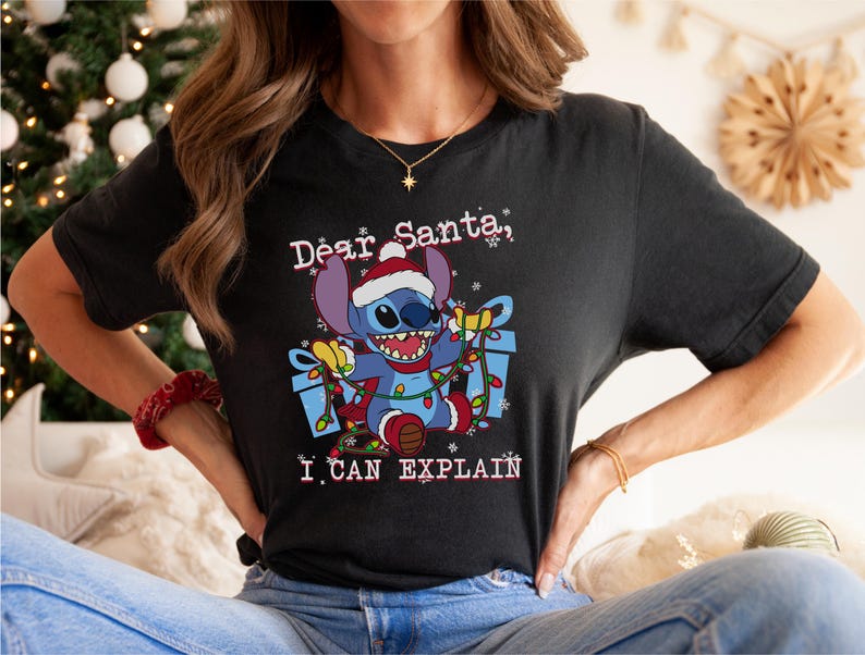 A woman wearing a black t-shirt with a graphic of a cartoon character and text that says "Dear Santa, I can explain".