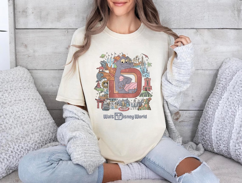a woman sitting on a bed wearing a t - shirt