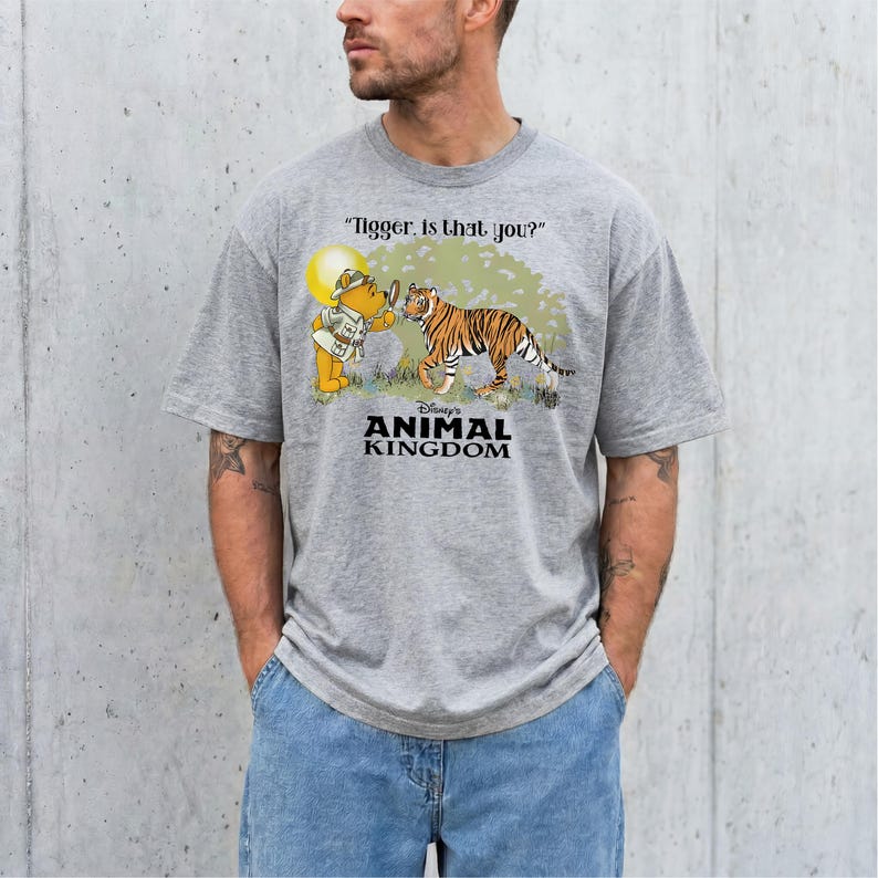 A man wearing a grey t-shirt with a graphic design depicting a tiger and a character from Winnie the Pooh.