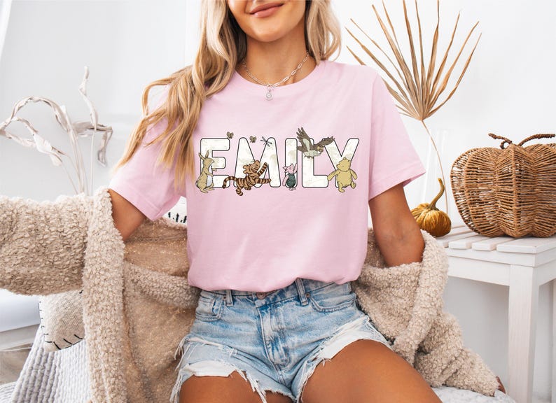 a woman sitting on a bench wearing a pink t - shirt