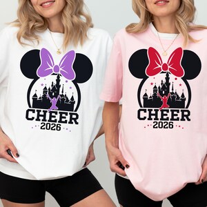 Two women wearing t-shirts with a Disney-themed design, including a castle and Minnie Mouse.