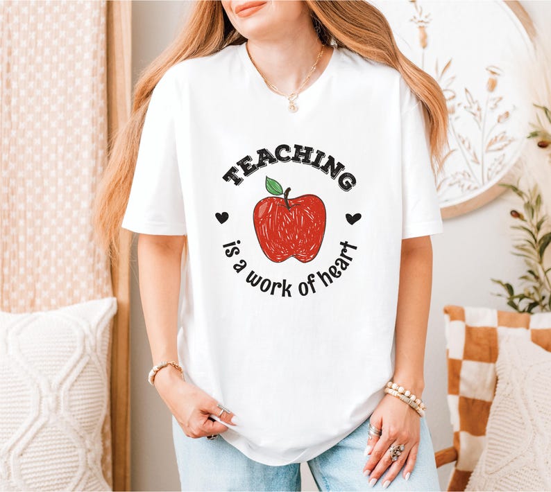 a woman wearing a teaching is a work of heart t - shirt