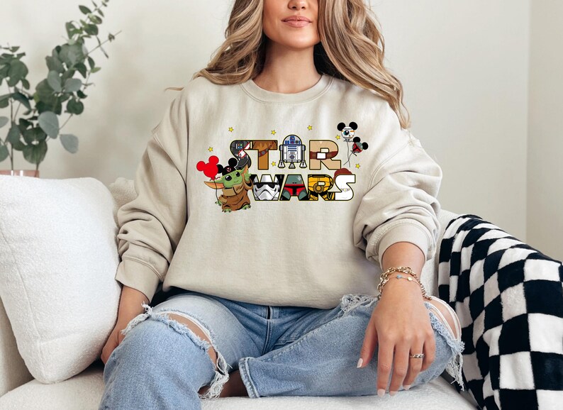 a woman sitting on a couch wearing a mickey mouse sweatshirt
