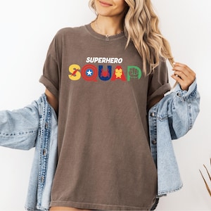 a woman wearing a brown shirt that says superhero squad