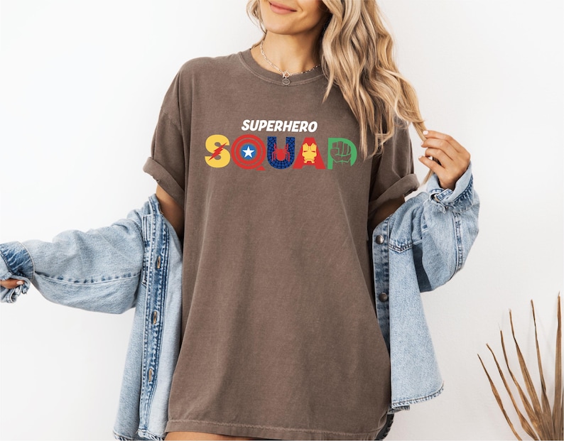 a woman wearing a brown shirt that says superhero squad