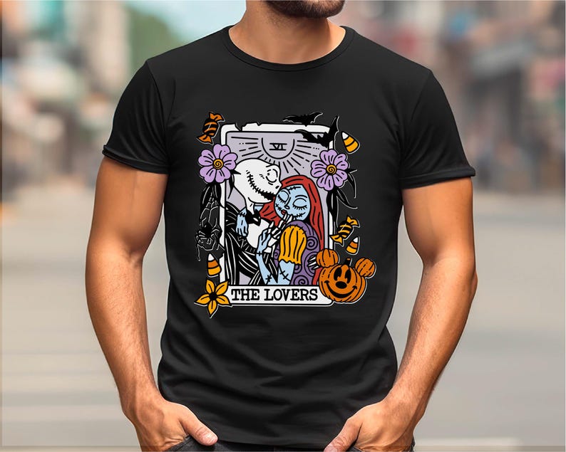 A black t-shirt with a graphic design featuring a couple embracing, surrounded by various Halloween-themed elements such as pumpkins, bats, and flowers.