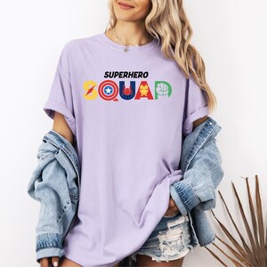 a woman wearing a purple shirt that says superhero squad