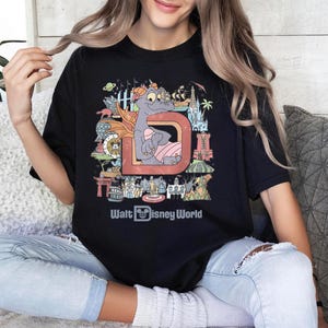a woman sitting on a couch wearing a disney world shirt