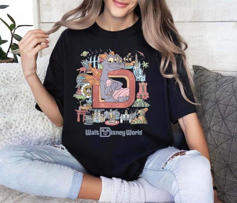 a woman sitting on a couch wearing a disney world shirt
