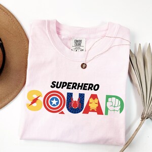 a pink shirt with the word superhero squad printed on it