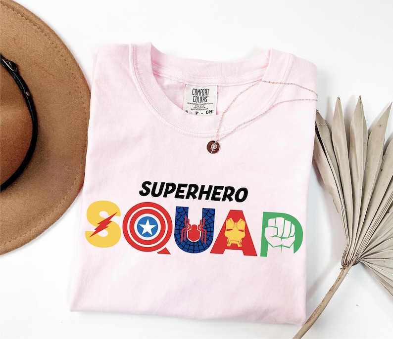 a pink shirt with the word superhero squad printed on it