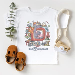 a t - shirt with a picture of a mouse on it next to a pair