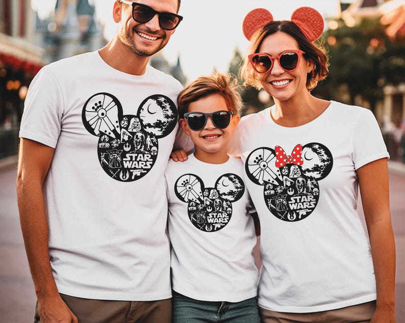 A family of three, consisting of a man, a woman, and a child, is standing together and smiling. They are all wearing white t-shirts with the Star Wars logo and Minnie Mouse designs.