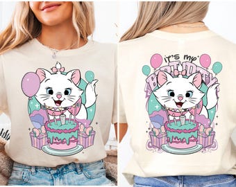 May include: A white t-shirt with a cartoon image of a white cat with pink ears and a pink bow on its head. The cat is sitting on a green and pink cake with candles. The text "It's my Birthday" is printed on the back of the shirt.