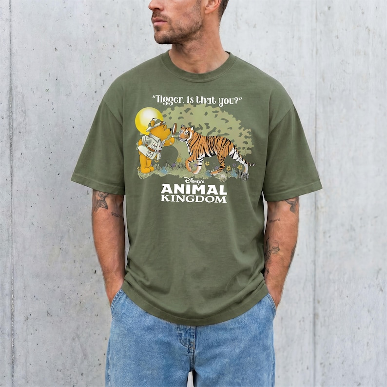 A man wearing a green t-shirt with a cartoon image of Tigger and Winnie the Pooh from the Disney animated film "Animal Kingdom".