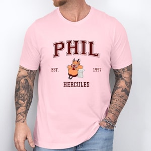 a man wearing a pink shirt with a cartoon character on it