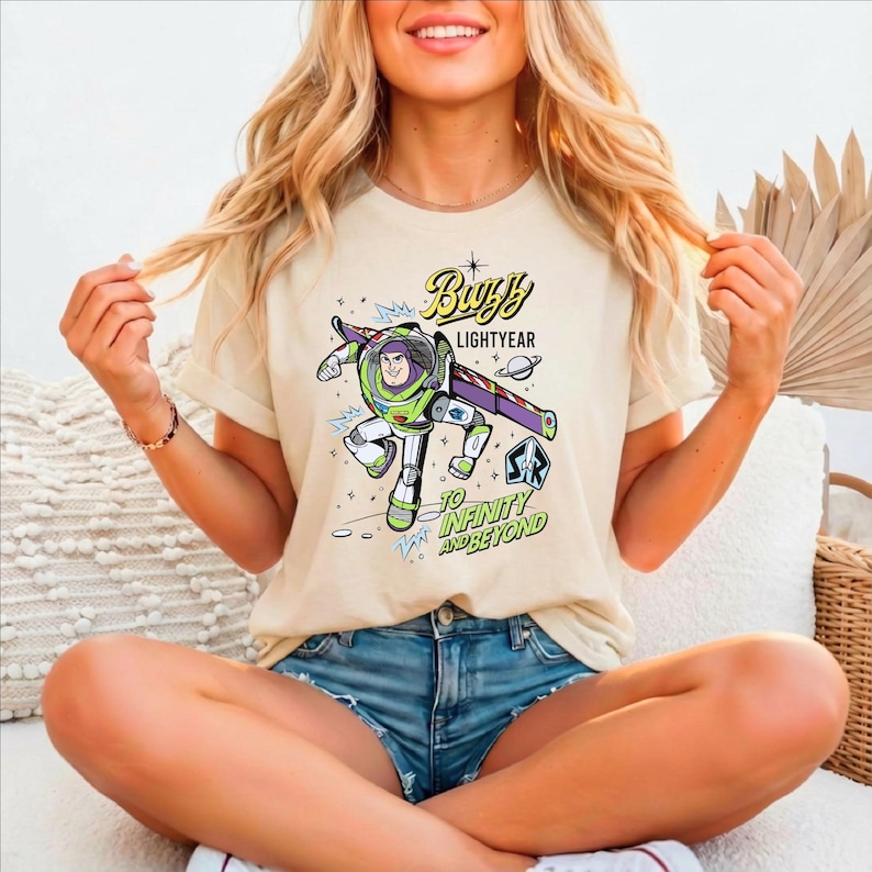 A smiling woman wearing a t-shirt with a character from the Toy Story franchise.