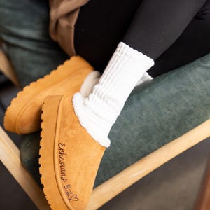 lifestyle photo of cozy scripture slippers with warm shearling lining and engraved Bible verse.
