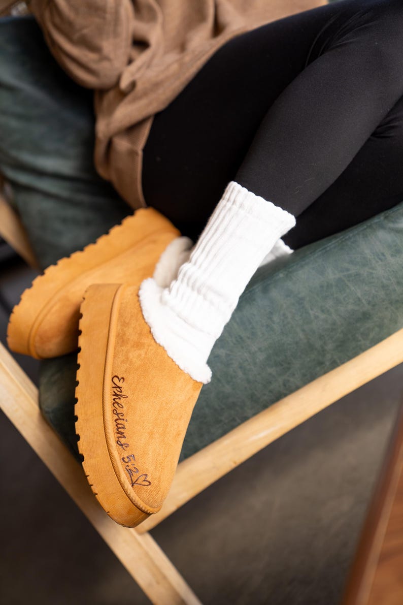 lifestyle photo of cozy scripture slippers with warm shearling lining and engraved Bible verse.