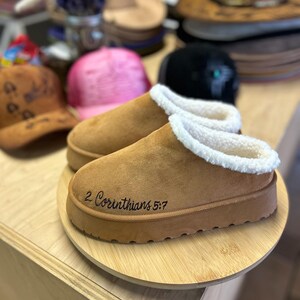 Front view of cozy scripture slippers with warm shearling lining and engraved Walk by Faith Bible verse.