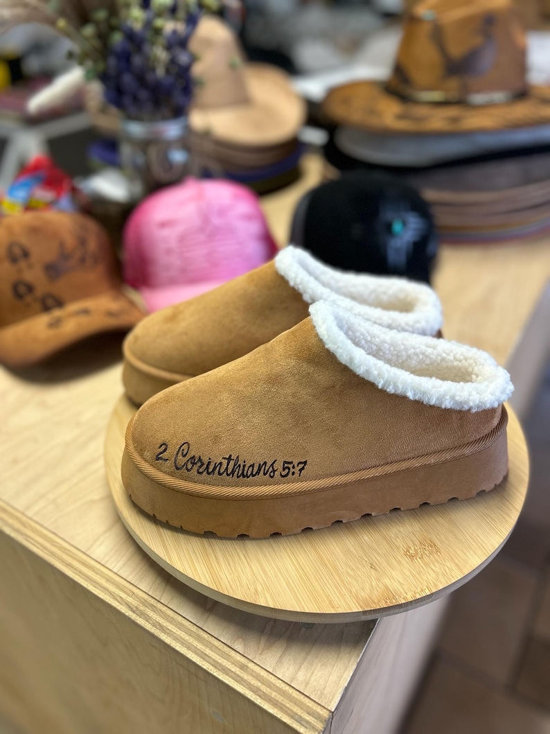 Front view of cozy scripture slippers with warm shearling lining and engraved Walk by Faith Bible verse.