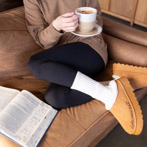 lifestyle photo of cozy scripture slippers with warm shearling lining and engraved Bible verse.