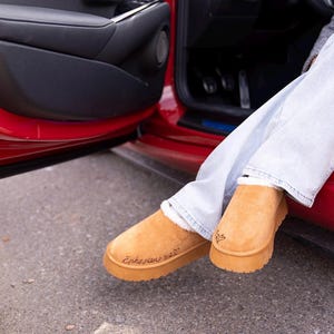 lifestyle photo of cozy scripture slippers with warm shearling lining and engraved Bible verse.