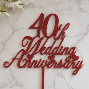 Op de afbeelding: Rode glitter 40e huwelijksverjaardag taarttopper met twee kleine hartjes.