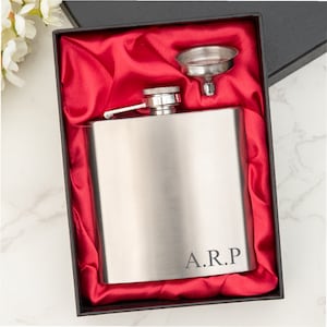 May include: A silver flask with a funnel in a red velvet box. The flask has the initials "A.R.P." engraved on it.
