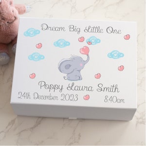 Könnte beinhalten: Weiße Erinnerungsbox mit einer Illustration eines grauen Elefanten, der rosa Herzen hält. Die Box trägt den Text "Dream Big Little One" und "Poppy Laura Smith" sowie das Datum "24th December 2023" und die Uhrzeit "8:40am".
