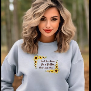May include: Light blue sweatshirt with a sunflower design and the text "Don't Be a Karen, Be a Button Elsa Cara Beth".