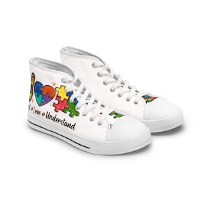 May include: White high-top sneakers with colorful puzzle piece and heart graphics. The shoes feature the words "Not Love Understand". The design includes a heart and puzzle pieces in various colors, with star accents.
