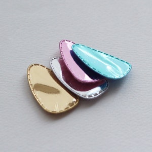 以下が含まれることがあります： 金、銀、ピンク、ブルーの金属製のヘアクリップ4個。クリップは涙の形で、光沢のある仕上げになっています。